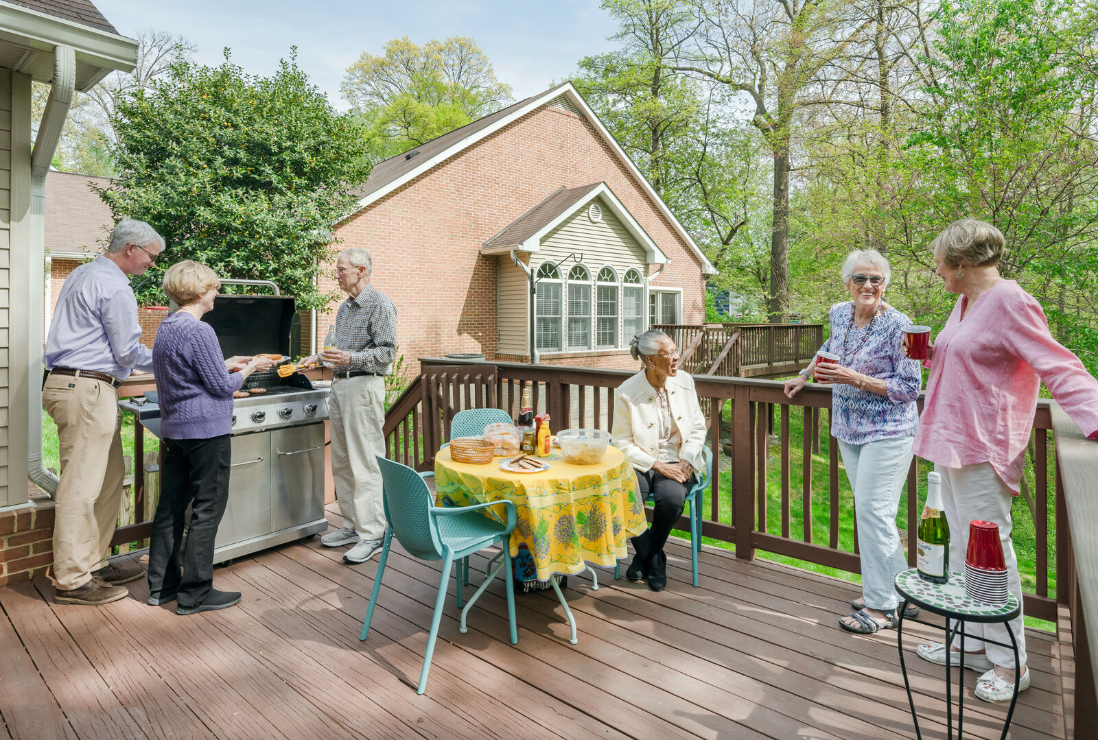 group of seniors out on a senior retirement home deck enjoying grilled foods and refreshments