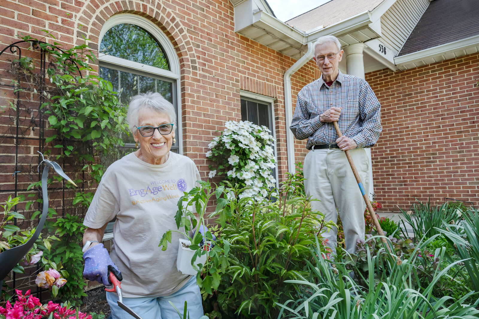 older couple outside of their senior living home gardening together