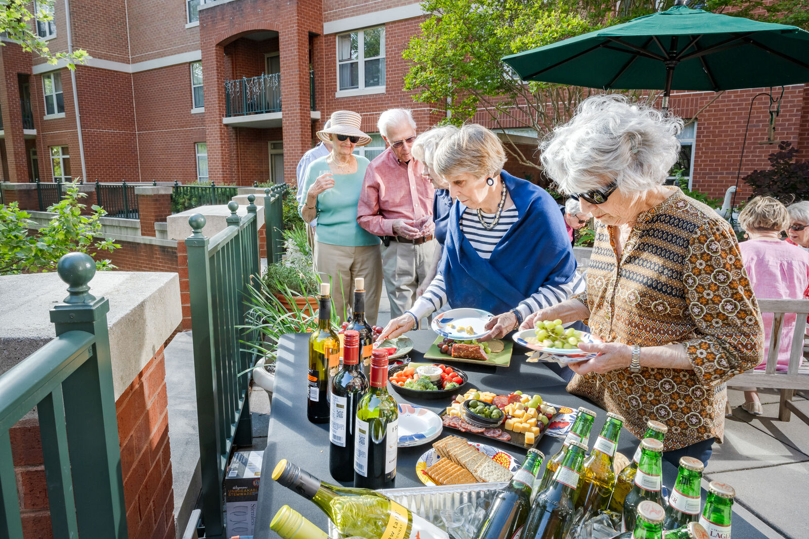 group of seniors at a patio party with food and alcohol