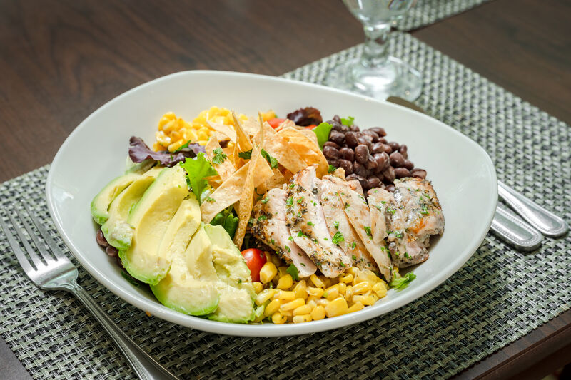 tex mex salad with fresh avocado, grilled chicken, black beans, and corn
