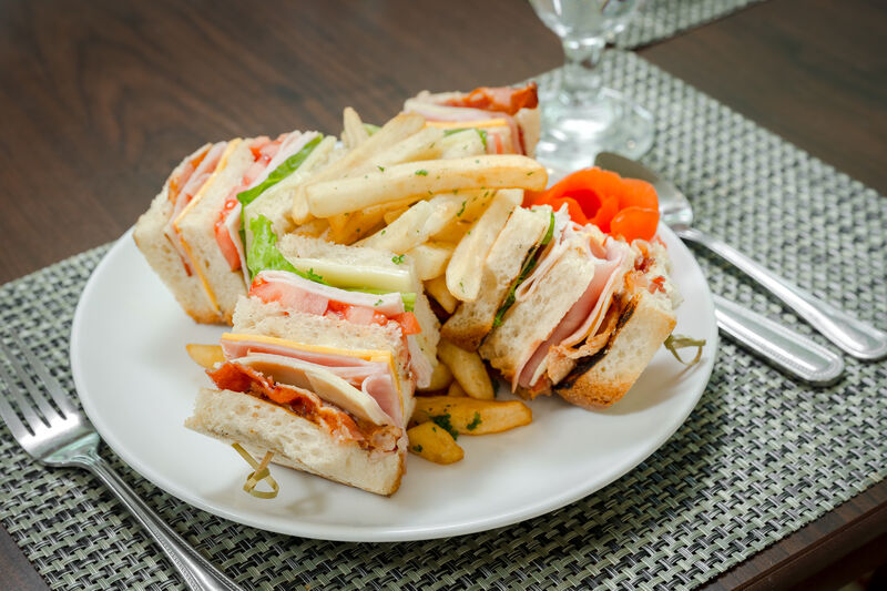 club sandwich on white plate with french fries